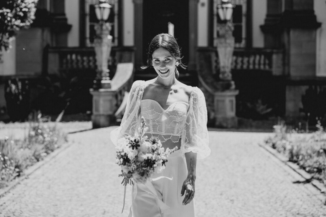 Schwarz-Weiß Porträt einer strahlenden Braut vor dem Museumssaal in Überlingen.