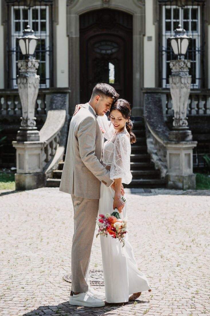 Brautpaar posiert vor dem barocken Eingangsportal des Museums für ihre Hochzeit in Überlingen.