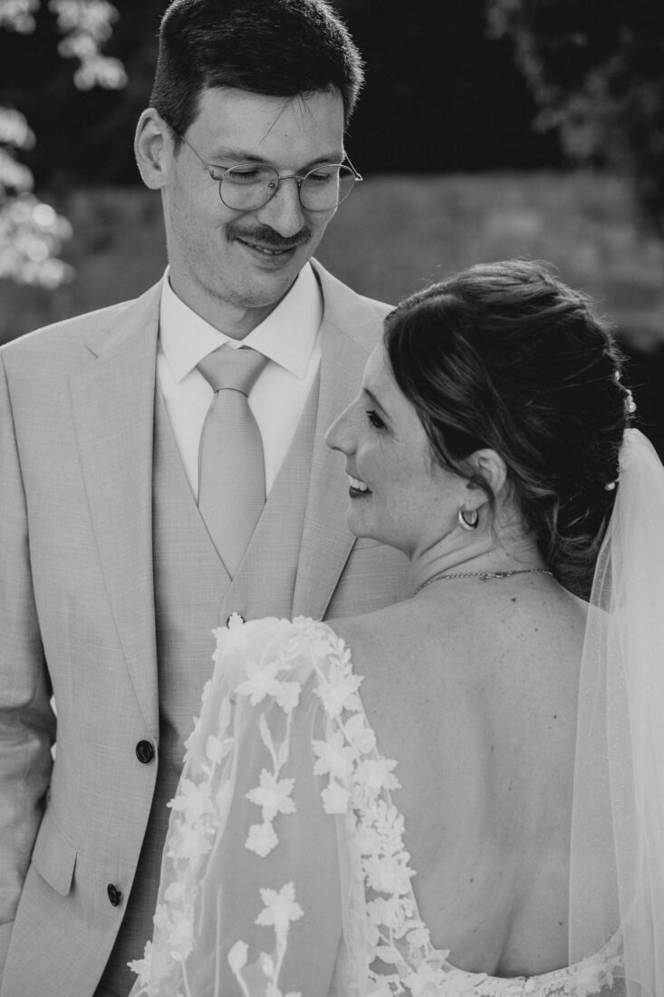 Nahaufnahme eines Brautpaares in Schwarz-Weiß, die sich liebevoll ansehen.