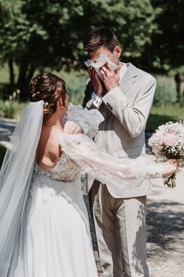 Emotionaler First Look am Bodensee: Der Bräutigam wischt sich Freudentränen ab, während er seine Braut zum ersten Mal sieht.