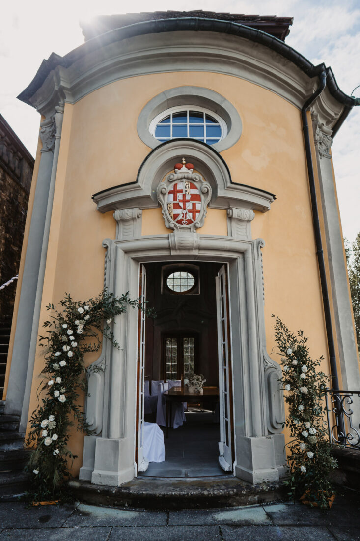 Festlich geschmückter Eingangsbereich im Teehäuschen des Schlosses Meersburg mit zwei großen Blumenarrangements für die Trauung.