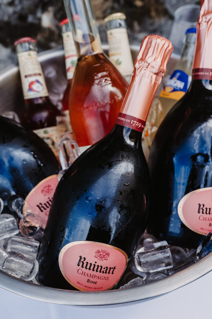 Ruinart Rosé Champagnerflaschen in einem silbernen Kühler mit Eiswürfeln beim Hochzeitsempfang am Bodensee.