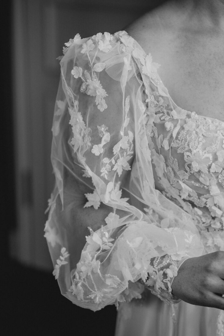 Detailaufnahme eines Brautkleid-Ärmels aus Tüll mit floralen Applikationen bei einer Hochzeit am Bodensee.