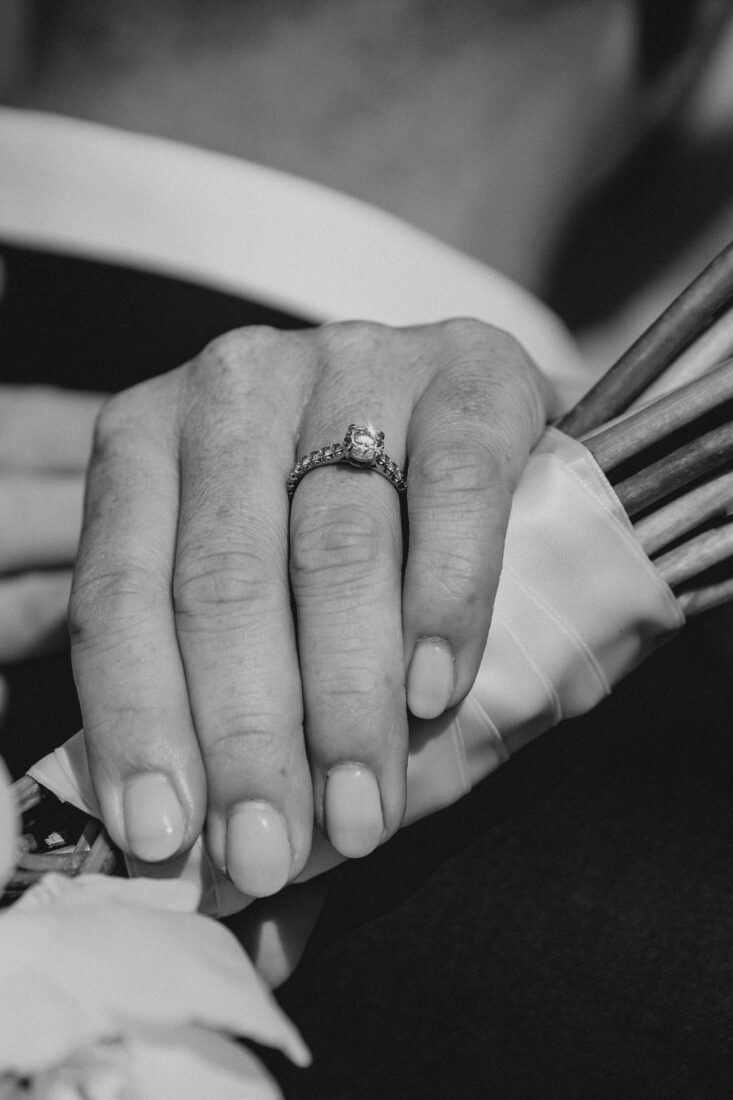 Makro-Aufnahme eines Diamantrings an der Hand der Braut, die ihren Brautstrauß hält – fotografiert in Meersburg.