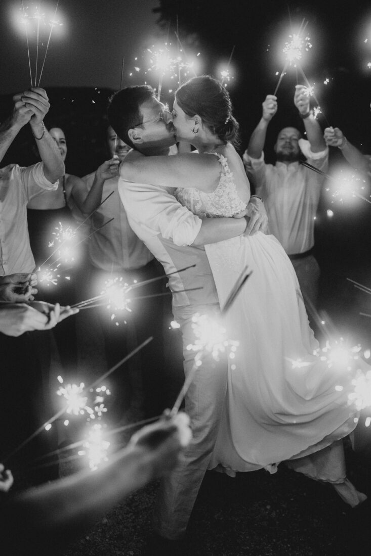 Romantischer Kuss des Brautpaares im Licht von Wunderkerzen bei ihrer Hochzeit auf Schloss Marbach (Schwarz-Weiß).