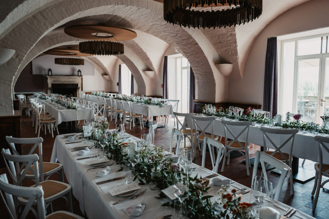 Festlich dekorierter Saal mit historischen Rundbögen im Schloss Marbach für eine Hochzeit am Untersee.