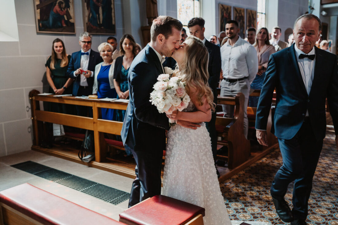 Brautpaar sieht sich das erste Mal und küsst sich nach dem Einzug der Braut bei ihrer kirchlichen Trauung in Bodman-Ludwigshafen.