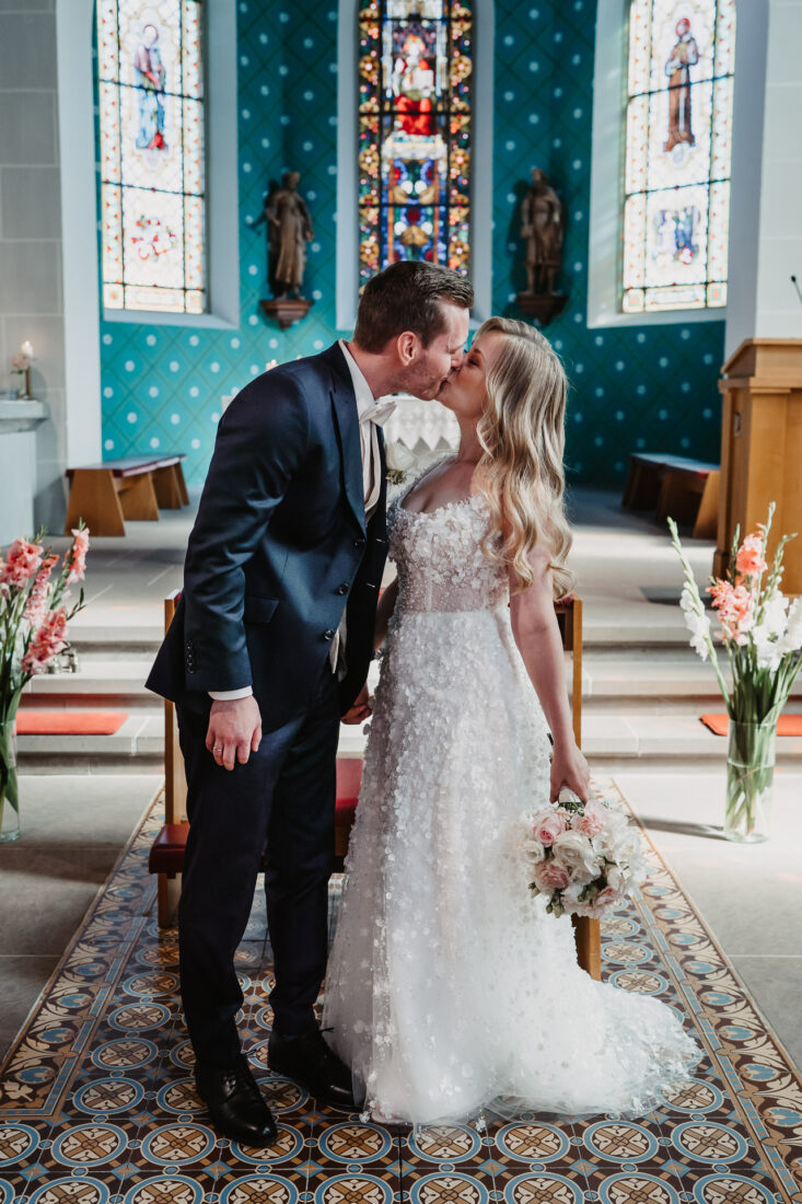 Brautpaar küsst sich vor dem Altar in der Kirche in Bodman-Ludwigshafen