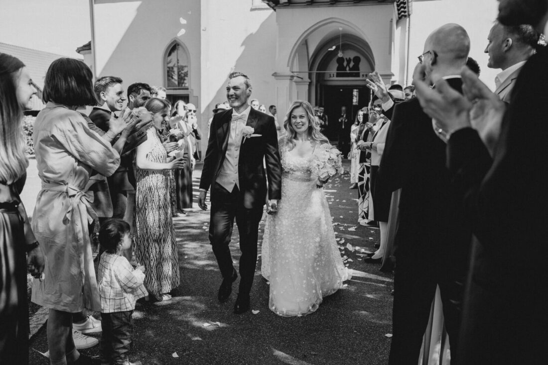 Hochzeitsgäste bilden vor der Kirche in Bodman-Ludwigshafen einen Spalier, durch den das Brautpaar freudestrahlend durchgeht